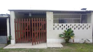 a red gate in front of a house at Casa 2 minutos a pé da Praia de INDAIÁ in Bertioga