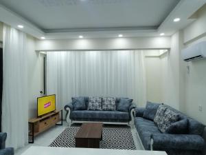 a living room with two blue couches and a tv at Deniz Apart in Demre