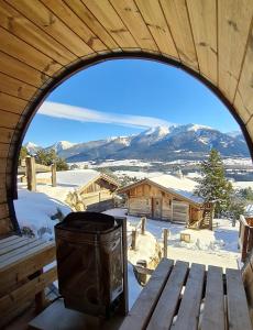 an arched window of a cabin with a grill and a bench at Chalet Vista - bolquère in Bolquere Pyrenees 2000