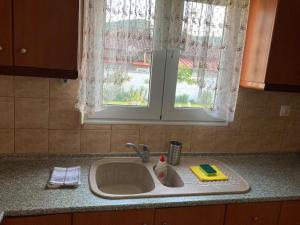 a kitchen sink with a detergent bottle and a window at Suzie's House - Road to Loutra Pozar in Polykárpion +39 photos