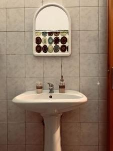 a bathroom with a sink and a mirror and a mirror at Suzie's House - Road to Loutra Pozar in Polykárpion