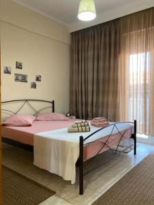 a bedroom with a bed with pink pillows and a window at Suzie's House - Road to Loutra Pozar in Polykárpion