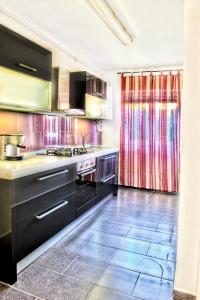 a kitchen with black cabinets and a tile floor at Apartments Andrea in Pula