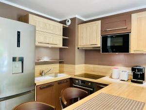 a kitchen with wooden cabinets and a table and chairs at Rena Bianca tout confort proche plage et centre ville in Propriano