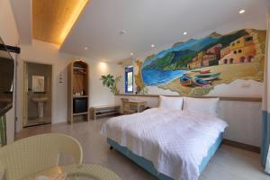 ein Schlafzimmer mit einem Bett und einem Wandgemälde in der Unterkunft Taroko Tkijig Ocean B&B in Chongde