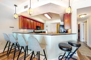 a kitchen with a bar with stools in it at Paradise Shores 305 in Mexico Beach