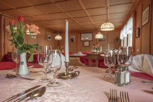 a table with wine glasses and a candle on it at Hotel-Restaurant Drei Tannen in Niederwald