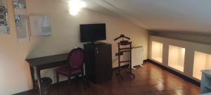 a room with a desk and a television and a chair at La Posada De La Magistral in Alcalá de Henares