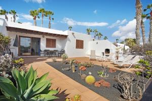 a house with a patio and a yard with plants at Puerto Chico R in Playa Blanca