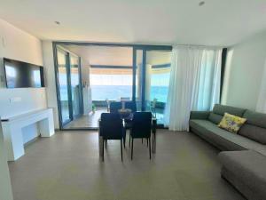 a living room with a couch and a table and chairs at Apartamento Infinium I - Exclusivo - Inmodream Calpe in Ifach