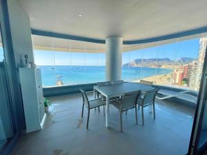 a dining room with a table and chairs and a large window at Apartamento Infinium I - Exclusivo - Inmodream Calpe in Ifach