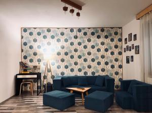 een woonkamer met een blauwe bank en een tafel bij Apartament Aretta in Braşov