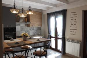 a kitchen with a table and chairs and a large window at Casa vacanza Il Mandarino in Viagrande