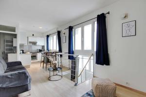 a living room with a couch and a kitchen at CMG-Cosy Apartment-Parc des Princes-Stade Rolland Garros in Boulogne-Billancourt
