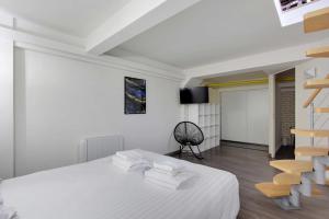 Cette chambre blanche dispose d'un lit et d'un escalier. dans l'établissement CMG-Cosy Apartment-Parc des Princes-Stade Rolland Garros, à Boulogne-Billancourt