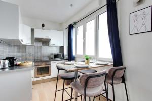 CMG-Cosy Apartment-Parc des Princes-Stade Rolland Garros في بولون بيانكور: مطبخ مع طاولة وكراسي في غرفة