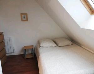 ein kleines Schlafzimmer mit einem Bett und einem Tisch in der Unterkunft Appartement calme aux portes de Rennes in Vezin-le-Coquet