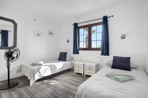 Un dormitorio con dos camas y una ventana. en Puerto Chico 1, en Playa Blanca 21 fotos más