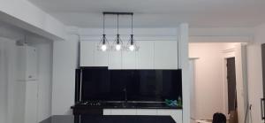 a kitchen with three lights hanging from the ceiling at Sweet Home in Iaşi