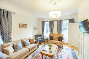 a living room with a couch and chairs and a table at Penninghame West Lodge in Newton Stewart