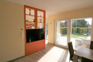 uma sala de estar com uma televisão e uma porta de vidro deslizante em Loreley Hills Residence em Sankt Goarshausen