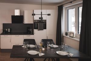 a dining room table with plates and wine glasses at Mountain Love Appartements in Haus im Ennstal