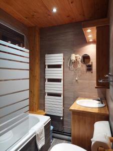La salle de bains est pourvue d'une baignoire et d'un lavabo. dans l'établissement Hôtel Aigliere, à Puy-Saint-Vincent