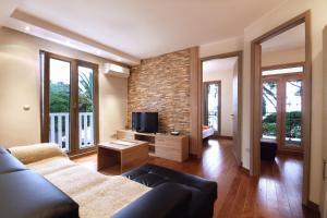 a living room with a couch and a tv at Apartments Dangubic in Petrovac na Moru