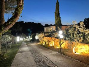 a sidewalk with street lights in a park at night at Les Herbes Folles in La Fare-les-Oliviers