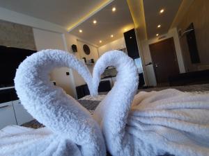 dois cisnes feitos de toalhas numa cama em Milmari P79 em Kopaonik