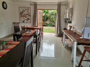 a dining room with tables and chairs and a window at Palm Tree BnB in East London