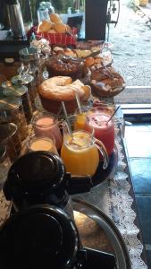 a buffet of food with glasses of orange juice and bread at Pousada Solar do Algarve in Paraty