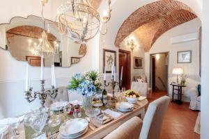 un comedor con una mesa con platos y vasos en Villa Chianti, your Secret 4 Bedrooms Retreat with View over the Vineyards in Marcialla, en Marcialla