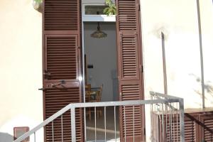 eine Tür zu einem Haus mit hölzernen Fensterläden darauf in der Unterkunft Appartamento 2m in Ameglia