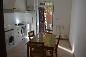 eine Küche mit einem Tisch, Stühlen und einem Herd in der Unterkunft Appartamento 2m in Ameglia