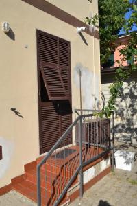 uma escada que leva a uma janela com uma persiana de madeira em Appartamento 2m em Ameglia