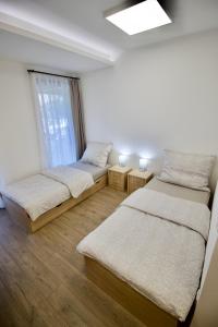 2 camas en una habitación con ventana en Sport Centrum Apartman en Pápa