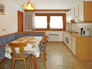 eine Küche mit einem Tisch und Stühlen sowie einem Tisch und einer Theke in der Unterkunft Apartment Ratschnhof - MHO585 by Interhome in Hippach