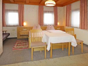 ein Schlafzimmer mit einem Bett und Stühlen in einem Zimmer in der Unterkunft Apartment Ratschnhof - MHO585 by Interhome in Hippach