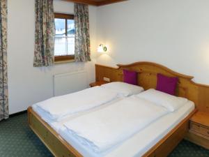 een slaapkamer met twee eenpersoonsbedden met paarse kussens bij Apartment Gredler-1 by Interhome in Mayrhofen