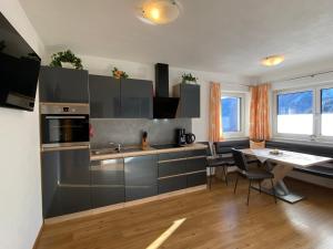 a kitchen with stainless steel cabinets and a table at Apartment Schöser by Interhome in Hippach +28 photos
