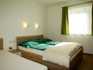 a bedroom with a bed with green sheets and a window at Apartment Schöser by Interhome in Hippach
