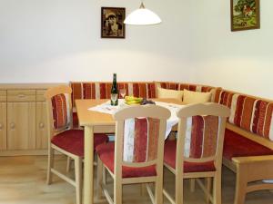 a dining room table with chairs and a bottle of wine at Apartment Moarerlechenhof - FGZ337 by Interhome in Hart im Zillertal