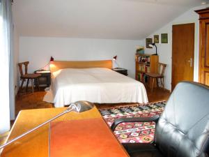 a bedroom with a bed and a desk and a couch at Holiday Home Reier by Interhome in Seeboden +12 photos