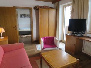 ein Wohnzimmer mit einem Sofa und einem TV in der Unterkunft Apartment Pendl - MHO550 by Interhome in Ramsau im Zillertal