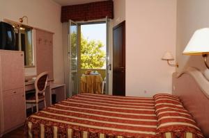 a bedroom with a bed and a dresser at Hotel Corallo in Francavilla al Mare