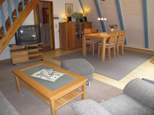 WingstにあるHoliday Home Meisenweg by Interhomeのリビングルーム(テーブル、椅子、テレビ付)