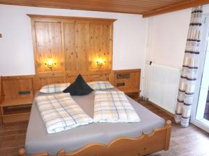 1 dormitorio con 1 cama grande y pared de madera en Holiday Home Burgner by Interhome, en Kappl
