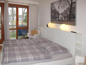 um quarto branco com uma cama e uma janela em Apartment Strandvilla - LUB110 by Interhome em Lubmin