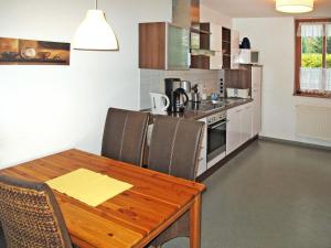 a kitchen with a wooden table with chairs and a dining room at Apartment Strandvilla - LUB110 by Interhome in Lubmin